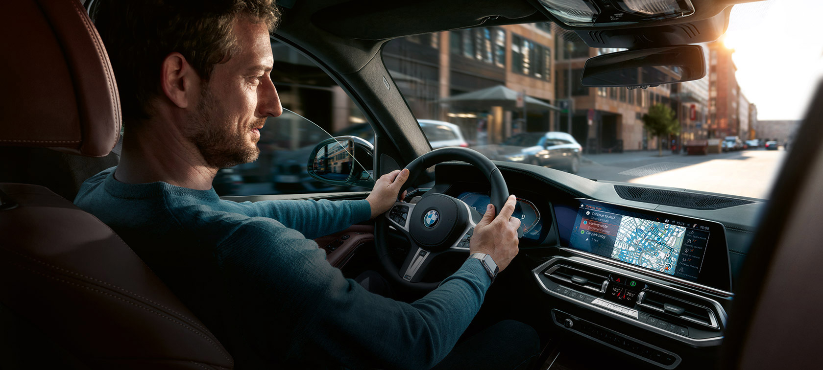 BMW Maps Navigation Un hombre viaja en un BMW con BMW Maps Navigation en el display de control