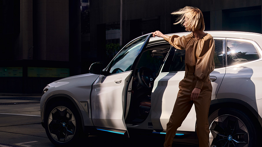 Mujer delante de un BMW iX3 BMW Financial Services Vehículo eléctrico BMW Híbrido Leasing Mujer delante de un BMW iX3