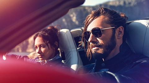 Hombre y mujer sentados en un BMW delante de un paisaje de montaña  BMW Financial Services Hombre y mujer sentados en un BMW delante de un paisaje de montaña