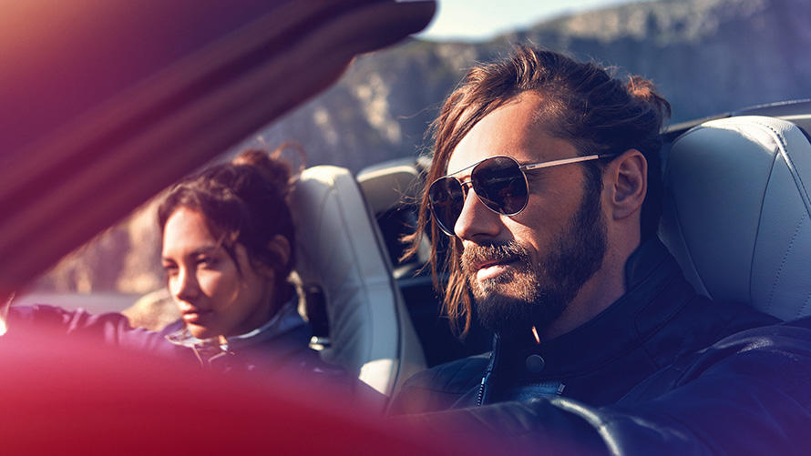 BMW Financial Services Hombre y mujer sentados en un BMW delante de un paisaje de montaña 