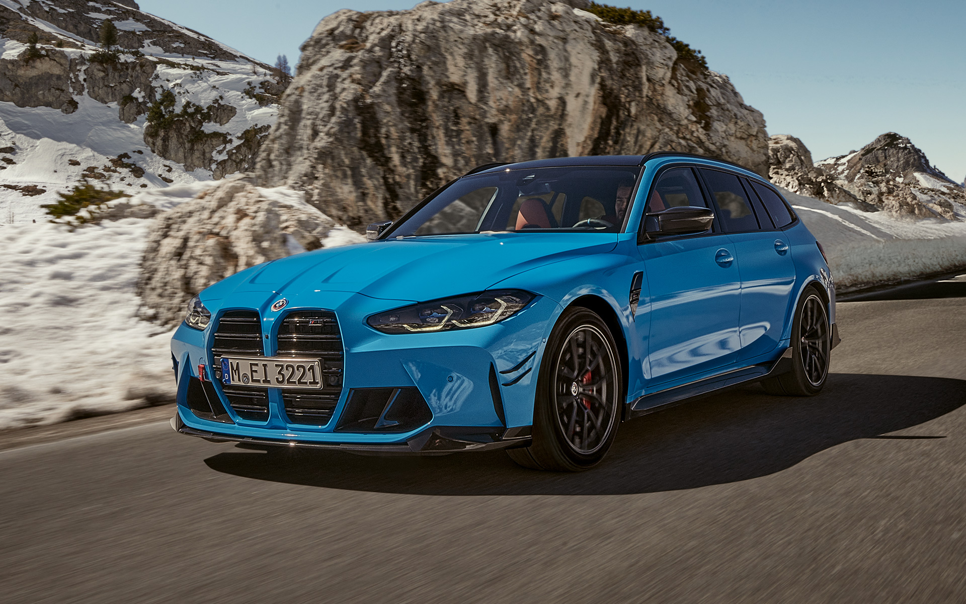 BMW M3 Touring G81 Accesorios M Performance, vista de tres cuartos del frontal, en marcha BMW M3 Touring G81 Accesorios M Performance, vista de tres cuartos del frontal, en marcha, delante de un paisaje de montaña