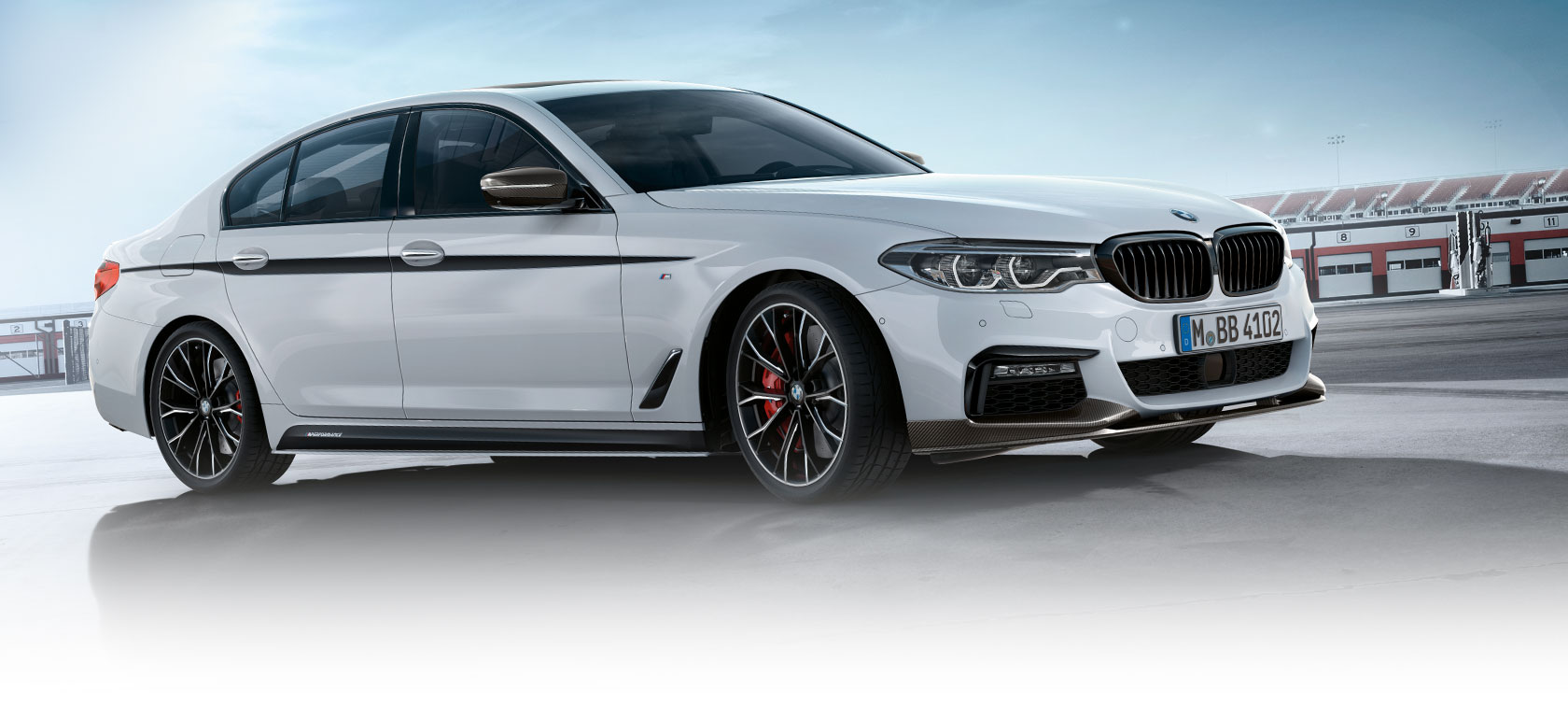 BMW Serie 3 Sedan, partes M Performance. Vista lateral del BMW Serie 3 Sedan en un estacionamiento con cielo azul.